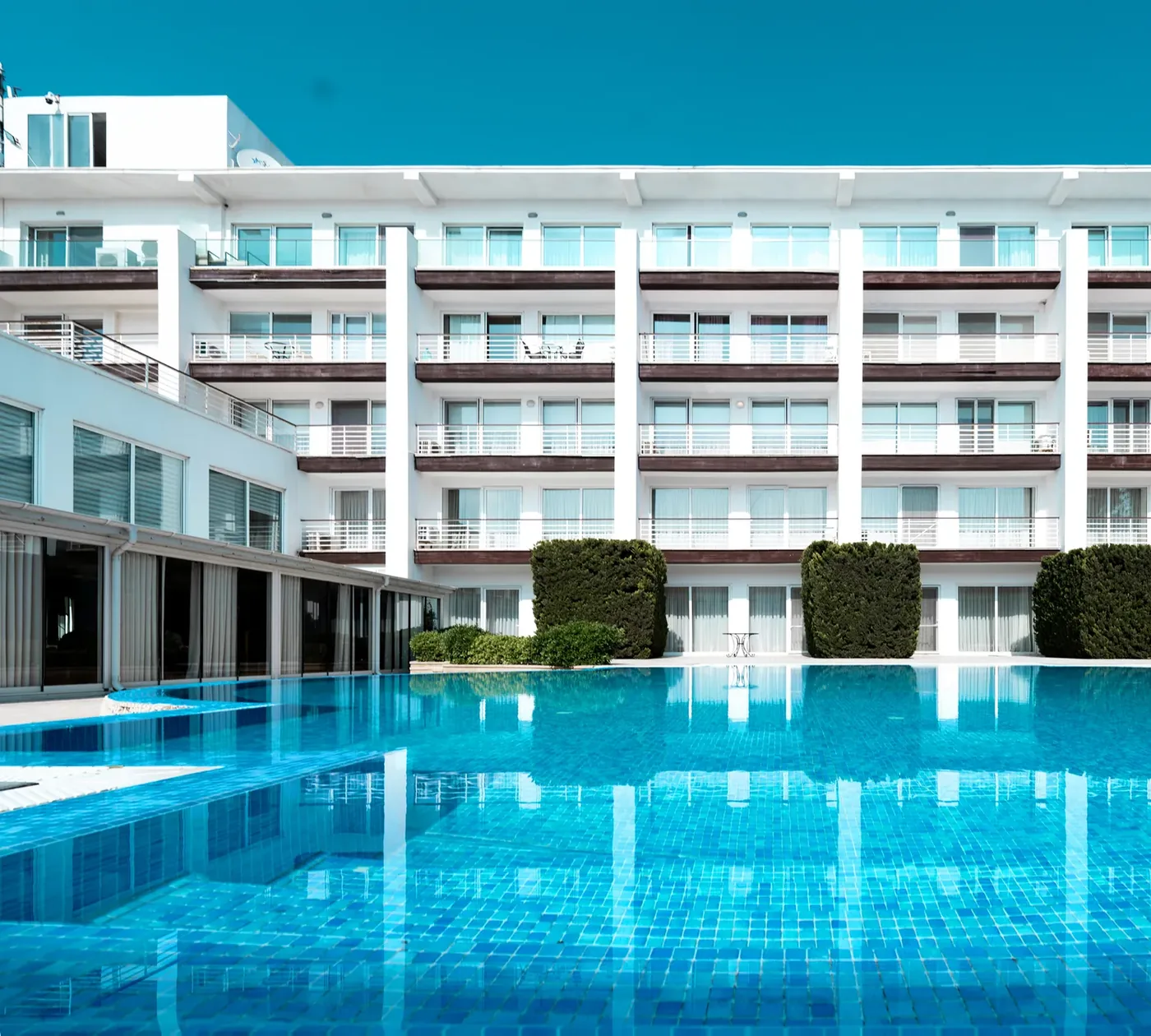 A pool in front of the hotel building